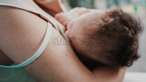 Video - Tender moment of a mother nursing her baby in natural light in the park