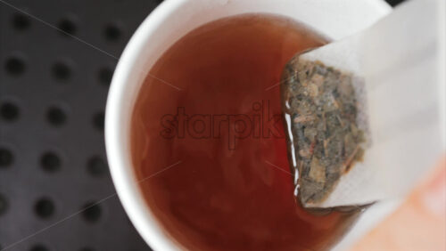 Video - Close up of a tea bag steeping in hot water, releasing rich colour and aroma