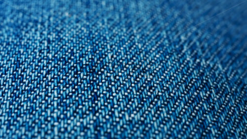 Video - Close up of blue denim fabric texture showing fine threads and detailed textile pattern