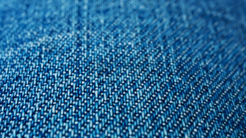 Video - Close up of blue denim fabric texture showing fine threads and detailed textile pattern