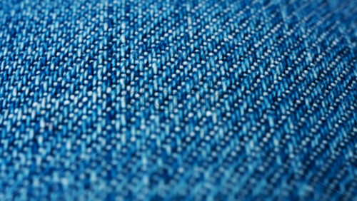Video - Close up of blue denim fabric texture showing fine threads and detailed textile pattern