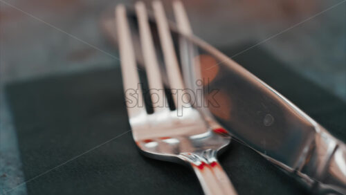 Video - Close up of silver cutlery placed neatly on a dark napkin at a restaurant