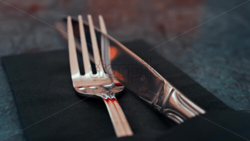 Video - Close up of silver cutlery placed neatly on a dark napkin at a restaurant