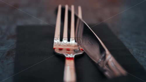 Video - Close up of silver cutlery placed neatly on a dark napkin at a restaurant