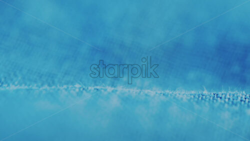 Video - Close up of blue denim fabric texture showing fine threads and detailed textile pattern