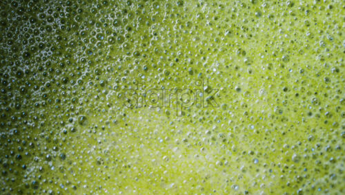 Video - Close up of a smooth matcha latte with vibrant green foam in a white cup