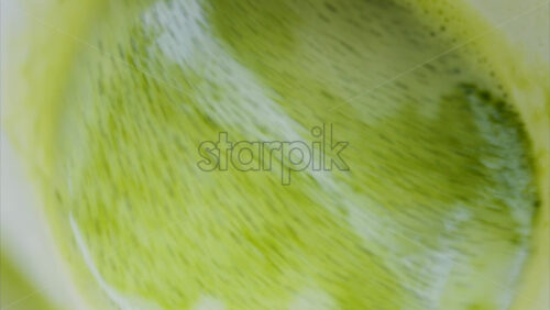 Video - Close up of a smooth matcha latte with vibrant green foam in a white cup