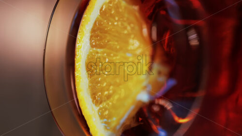 Video - Close up of a Negroni cocktail with orange slice and ice cubes on a wooden table