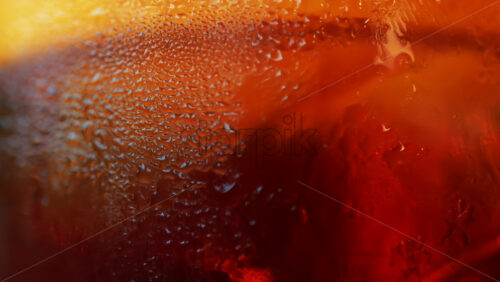 Video - Close up of a Negroni cocktail with orange slice and ice cubes on a wooden table