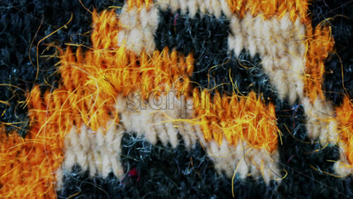 Video - Close up view of woven wool fibers in warm yellow and black tones
