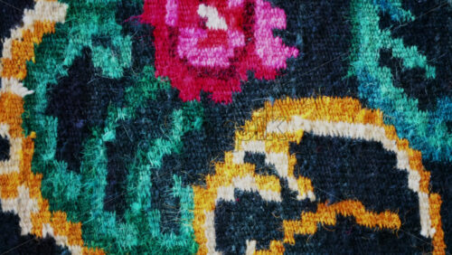Video - Close up of a traditional floral carpet with vivid colors and intricate woven details