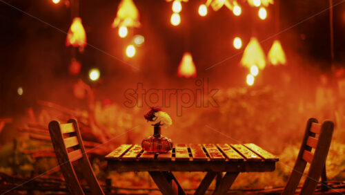 Video - A wooden table with flowers illuminated by soft hanging lights