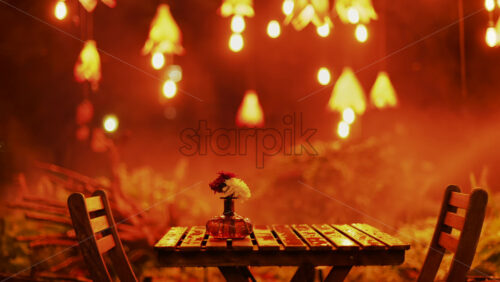 Video - A wooden table with flowers illuminated by soft hanging lights