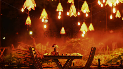 Video - A wooden table with flowers illuminated by soft hanging lights