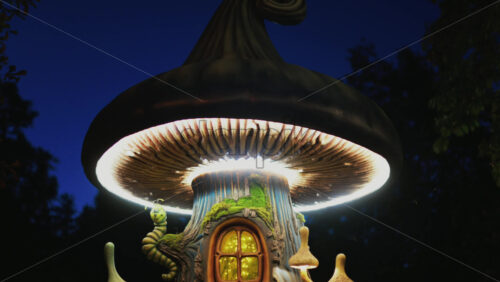 Video - A miniature fantasy tree house with glowing windows, mushrooms, and a smiling caterpillar figure
