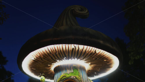 Video - A miniature fantasy tree house with glowing windows, mushrooms, and a smiling caterpillar figure