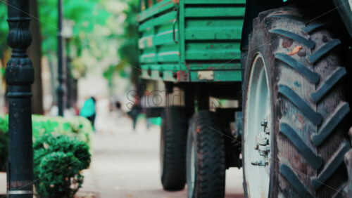 Video - Chisinau, Moldova - September 25, 2025: Urban tractor collects leaves in a green city park as people stroll in the background