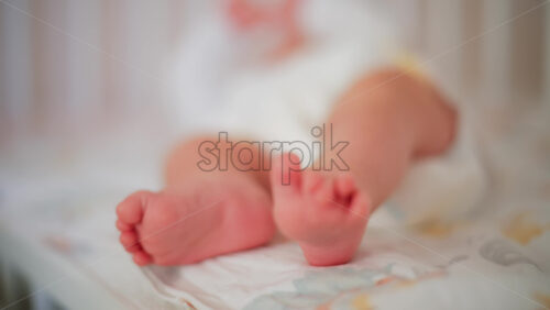 Video - Close up of baby's feet moving around on a bed
