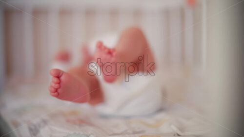 Video - Close up of baby's feet moving around on a bed