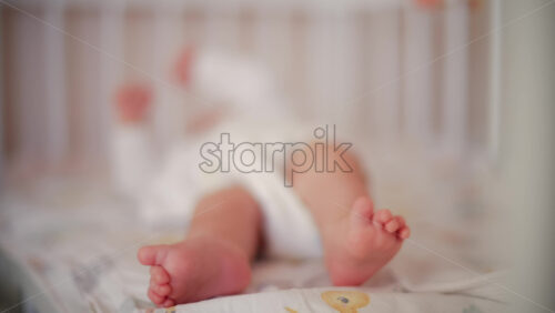 Video - Close up of baby's feet moving around on a bed