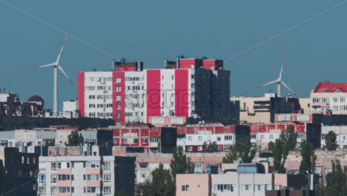 Video - View of an urban skyline with wind turbines in the background