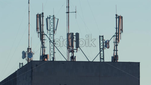 Video - Antennas and communication towers stand on top of a building under the warm morning light