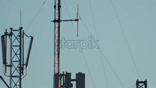 Video - Antennas and communication towers stand on top of a building under the warm morning light