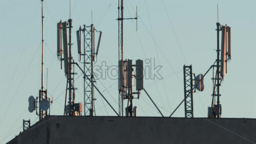 Video - Antennas and communication towers stand on top of a building under the warm morning light