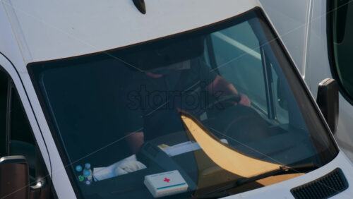 Video - Chisinau, Moldova - September 28, 2025: A man siting behind the wheel of a white van, viewed through the windshield