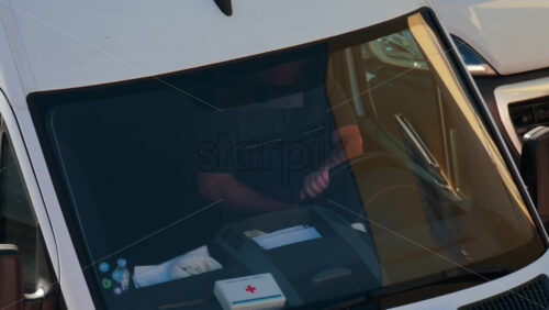Video - Chisinau, Moldova - September 28, 2025: A man siting behind the wheel of a white van, viewed through the windshield