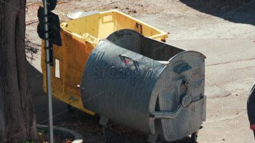 Video - Chisinau, Moldova - September 30, 2025: An elderly man throws a bag of waste into a metal trash bin outdoors