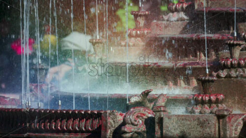 Video - View of a decorative fountain with sparkling water droplets illuminated by sunlight in a park