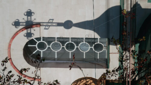 Video - Beautiful architectural detail showing the shadow of a church cross projected on a wall with circular windows. Vertical