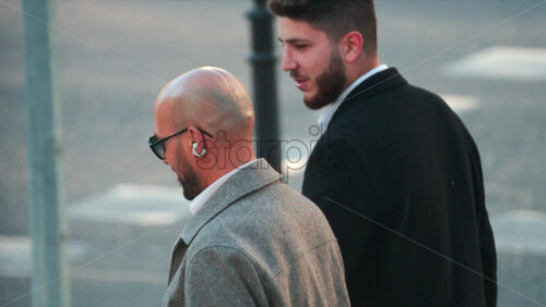 Video - Chisinau, Moldova - September 30, 2025: Two stylish men crossing the street in the city centre in daylight