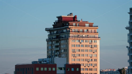 Video - Urban residential tower with warm light reflections at sunset