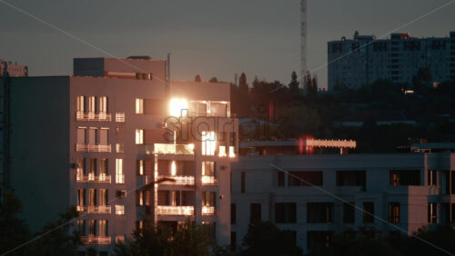Video - Evening light reflecting off modern apartment buildings, creating a golden glow across the cityscape