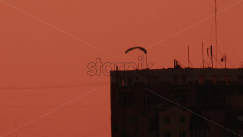 Video - A paramotor glides smoothly through a warm toned sky at sunset