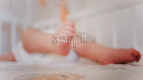 Video - Close up of baby's feet moving around on a bed