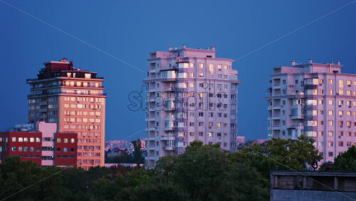 Video - High rise apartments glow under the blue evening sky