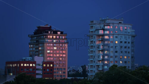 Video - High rise apartments glow under the blue evening sky