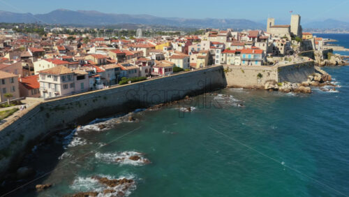 Video – Aerial drone view of Antibes Old Town with terracotta rooftops, palm trees, and medieval fortifications overlooking the Mediterranean Sea - Starpik Stock