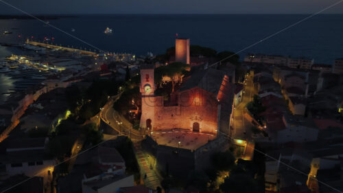Video – Aerial drone view of Cannes Old Port and the medieval Suquet quarter, with yachts docked in the marina and the Church of Our Lady of Esperance beautifully illuminated - Starpik Stock