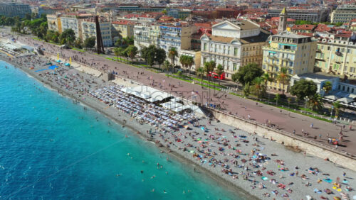 Video – Aerial drone view of Nice Old Town with colorful buildings, terracotta rooftops, and busy beachfront - Starpik Stock