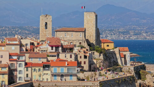 Video – Aerial drone view of the Picasso Museum in Antibes Old Town, with medieval stone towers, French flag flying, and terracotta rooftops overlooking the sea - Starpik Stock