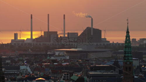 Video – Aerial drone view of the skyline of Copenhagen, Denmark with Amager Bakke and offshore wind turbines at sunrise - Starpik Stock