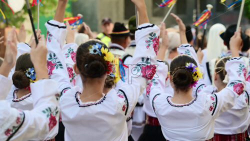 Video - A group of dancers wearing embroidered garments joyfully performs traditional folk dance at a vibrant cultural festival outdoor