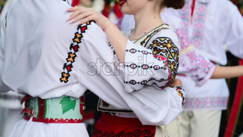 Video - Participants showcase colorful folk costumes and intricate dance moves during a lively cultural festival. The joyful atmosphere highlights community spirit and tradition. Slow motion