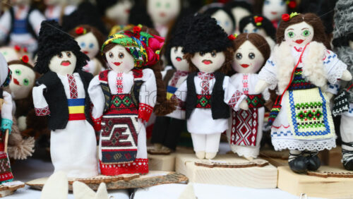 Video - Colorful handmade dolls dressed in traditional Moldavian and Romanian clothing are displayed at a local craft fair.
