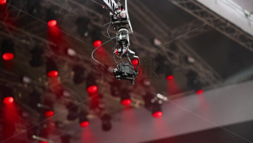 Video - Camera crane captures an aerial view of a lively concert under bright colored and flashing lights