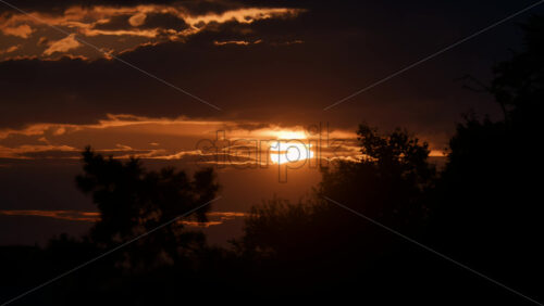 Video - Stunning sunset over the horizon with clouds creating a dramatic sky in a serene landscape